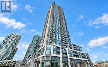 Mississauga (Creditview) condo for rent - A tall building with a glass facade stands in front of other buildings.