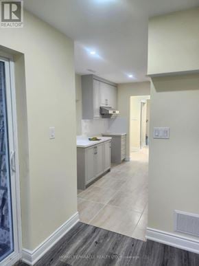 Barrie (Cundles East) apartment for rent - A kitchen with a refrigerator, sink, and cabinets.