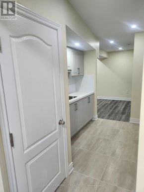 Barrie (Cundles East) apartment for rent - A white door is on the left of a hallway with a tile floor.