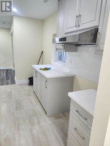 Barrie (Cundles East) apartment for rent - A kitchen with white cabinets and a tile floor.