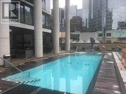 Toronto (Waterfront Communities) condo for rent - A pool in a city setting with a Realty sign in the background.