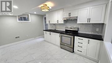 Markham (Greensborough) apartment for rent - A kitchen with white cabinets and a marble floor.