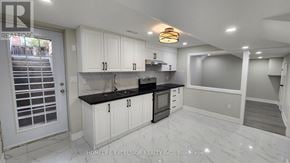 Markham (Greensborough) apartment for rent - A modern kitchen with white cabinets and black countertops.