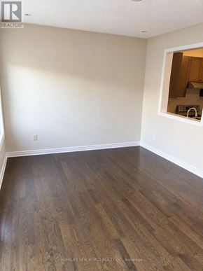 Richmond Hill (Jefferson) townhouse for rent - A room with wooden flooring and a small kitchen visible through a window.