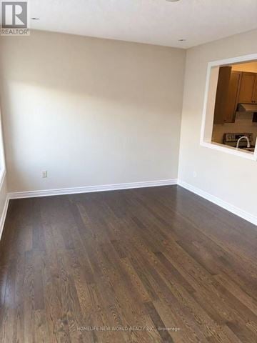 Richmond Hill (Jefferson) townhouse for rent - A room with wooden flooring and a small kitchen visible through a window.