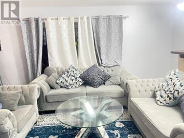 Pickering (Rougemount) apartment for rent - A living room with a white couch and a glass coffee table.