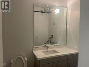 Burnaby apartment for rent - A bathroom with a sink, mirror, and toilet.