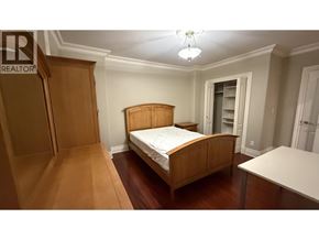 Burnaby apartment for rent - A bedroom with a bed, dresser, and wardrobe.