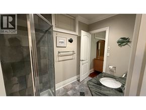 Burnaby apartment for rent - A bathroom with a marble countertop and a glass shower stall.