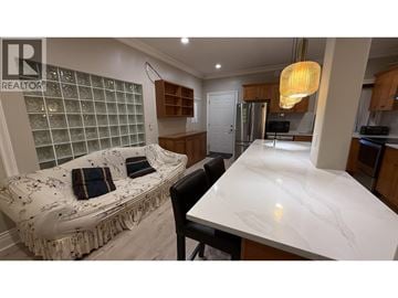 Burnaby apartment for rent - A kitchen with a marble countertop and a bench with cushions.
