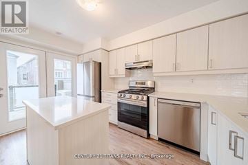 Pickering townhouse for rent - A kitchen with white cabinets and appliances is shown.