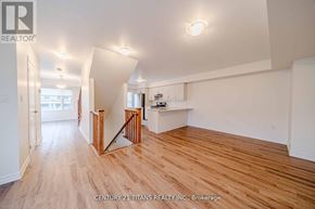 Pickering townhouse for rent - A spacious room with wooden floors and white walls.
