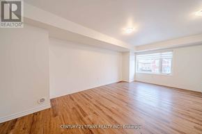 Pickering townhouse for rent - A room with wooden flooring and white walls, with a window letting in natural light.
