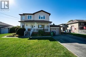 Mississauga (Cooksville) apartment for rent - A house with a well-maintained lawn and a clear sky above.