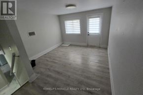 Kitchener duplex for rent - A room with wooden flooring and white walls, with a door and a window with blinds.