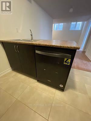 Barrie (Innis-Shore) apartment for rent - A kitchen island with a sink and a black cabinet with a yellow sticker on it.