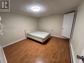 Mississauga (Erindale) apartment for rent - A bedroom with a bed, wooden floors, and a white door.