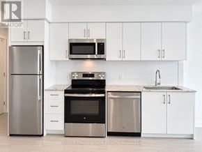 Toronto (Humber Heights) condo for rent - A modern kitchen with white cabinets and stainless steel appliances.
