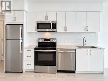 Toronto (Humber Heights) condo for rent - A modern kitchen with white cabinets and stainless steel appliances.