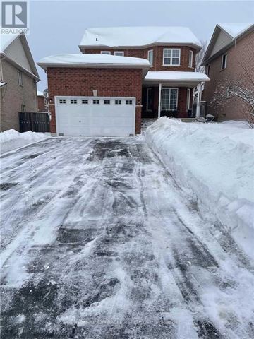 Barrie (Ardagh) apartment for rent - A snow-covered driveway leads to a brick house with a white garage door.