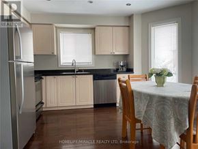 Barrie (Ardagh) apartment for rent - A kitchen with wooden chairs and a table with a vase of flowers on it.