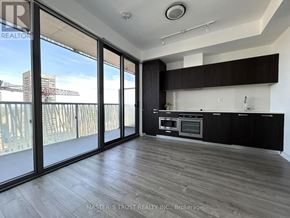 Toronto (Church-Yonge Corridor) condo for rent - A modern kitchen with dark wood floors and a large window overlooking a construction site.