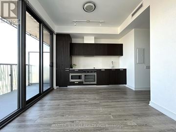 Toronto (Church-Yonge Corridor) condo for rent - A spacious kitchen with dark wood cabinets and a large island.
