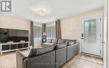 London East (East D) apartment for rent - A living room with a grey sofa and a glass door.