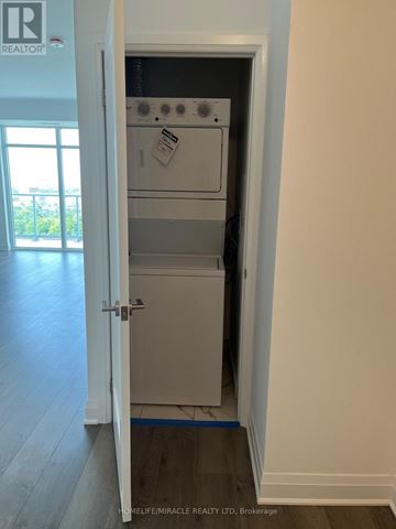 Toronto (Tam O'shanter-Sullivan) condo for rent - A white door is open to a small kitchen with a dishwasher and oven.