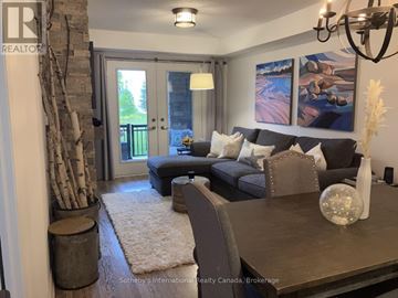 Collingwood condo for rent - A living room with a grey couch and a wooden table.