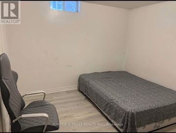 Markham (Milliken Mills West) apartment for rent - A bedroom with a bed, chair, and window.