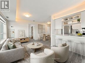 Brampton (Queen Street Corridor) condo for rent - A well-lit, modern living room with a kitchen area in the background.