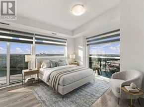 Brampton (Queen Street Corridor) condo for rent - A bedroom with a large bed, a chair, and a view of the city.