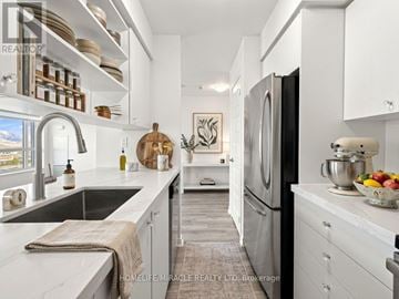 Brampton (Queen Street Corridor) condo for rent - A modern kitchen with a black refrigerator and stainless steel appliances.