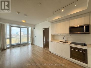 Toronto (Henry Farm) condo for rent - A modern kitchen with wooden floors and white cabinets.