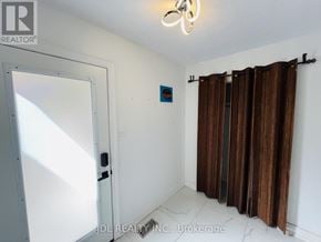 Whitby (Pringle Creek) apartment for rent - A room with a white door, a window with brown curtains, and a light fixture on the ceiling.