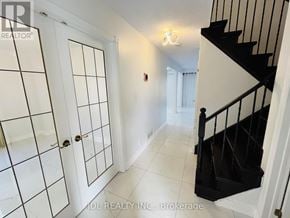 Whitby (Pringle Creek) apartment for rent - A hallway with a staircase and a door with a window.