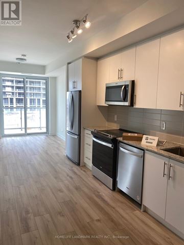 Oakville (Jm Joshua Meadows) condo for rent - A kitchen with white cabinets and a wooden floor.