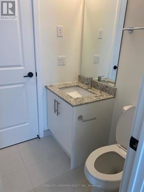 Oakville (Jm Joshua Meadows) condo for rent - A white bathroom with a toilet, sink, and mirror.
