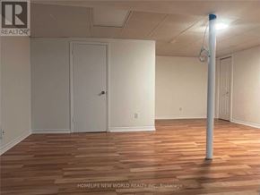 Richmond Hill (Crosby) apartment for rent - A room with wooden flooring and white walls, with a door and a pole in the middle.