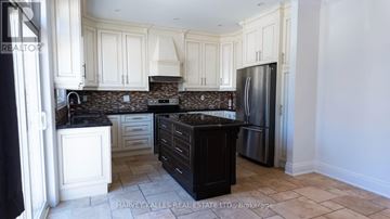 Toronto (Oakwood Village) apartment for rent - A kitchen with white cabinets and a black island.