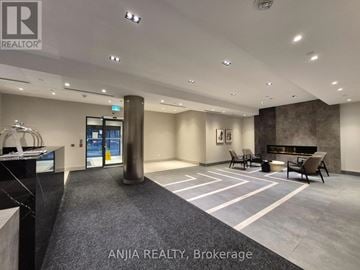 Toronto (Tam O'shanter-Sullivan) condo for rent - A spacious office lobby with a reception desk and a fireplace.