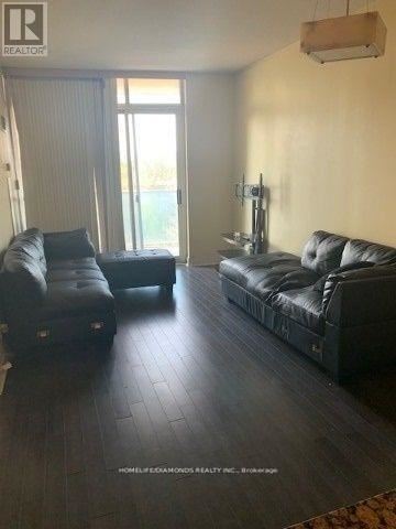 Mississauga (City Centre) condo for rent - A living room with black leather furniture and a large window.