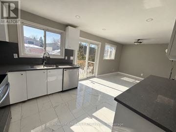 Brampton (Brampton South) apartment for rent - A spacious kitchen with white cabinets and a black countertop.