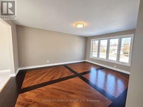Brampton (Brampton South) apartment for rent - A room with wooden flooring and a window showing a view of buildings outside.