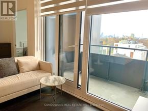 Toronto (Humewood-Cedarvale) condo for rent - A living room with a couch, a table, and a view of the city through the windows.