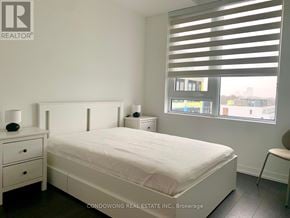 Toronto (Humewood-Cedarvale) condo for rent - A bedroom with a white bed, nightstand, and chair.