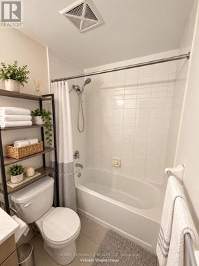 Toronto (Malvern) condo for rent - A white bathroom with a toilet, a shower, and a towel rack.