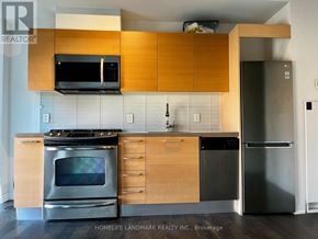 Toronto (Moss Park) condo for rent - A kitchen with wooden cabinets and stainless steel appliances.