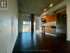 Toronto (Moss Park) condo for rent - A kitchen area with wooden floors and a stainless steel refrigerator.